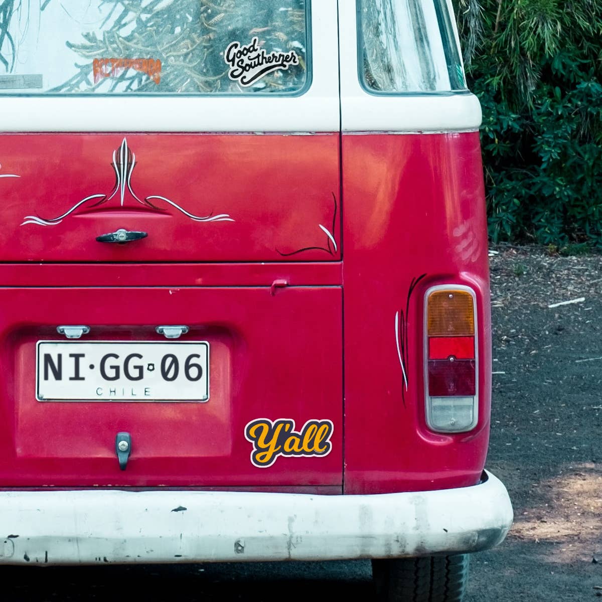 Red van with 'Y'all' decal and license plate on a road.