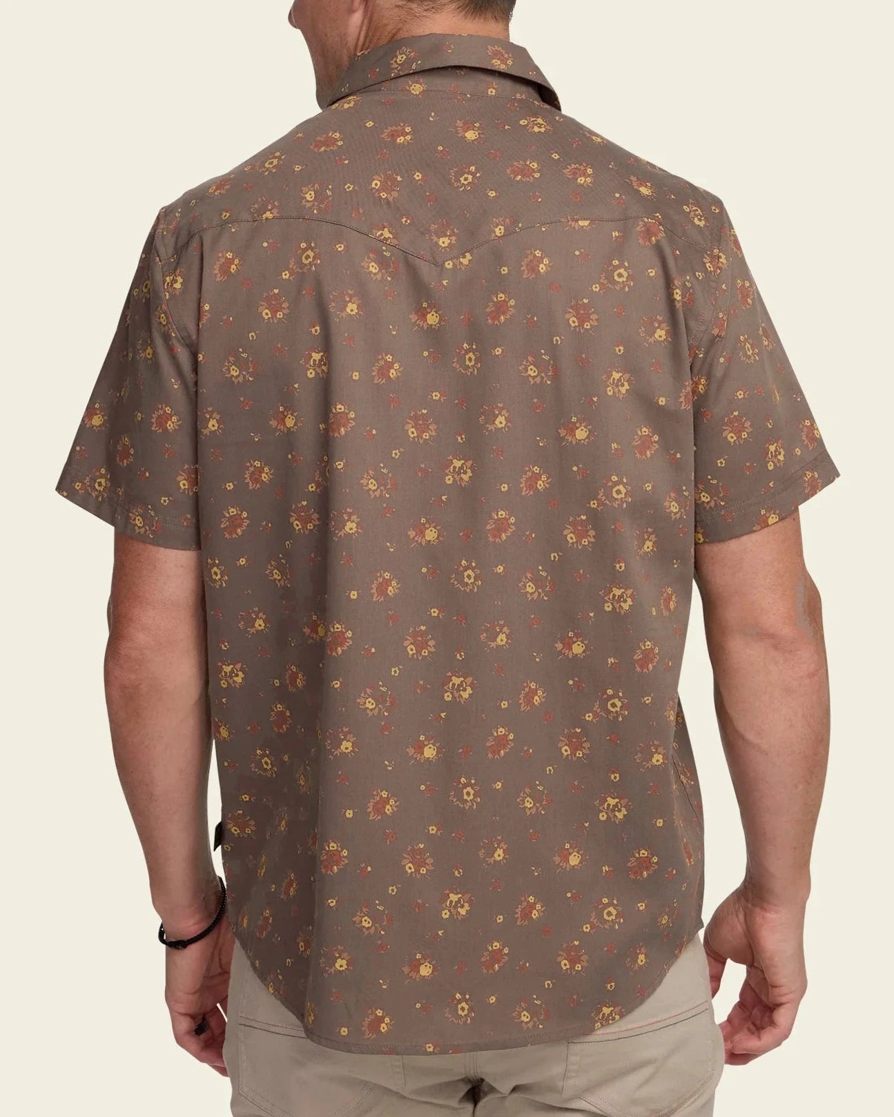 Man wearing a brown patterned shirt on a beige background
