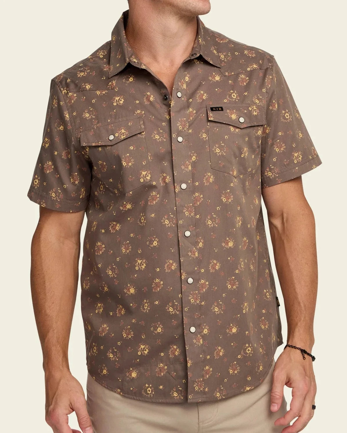 Man wearing a brown patterned shirt on a beige background