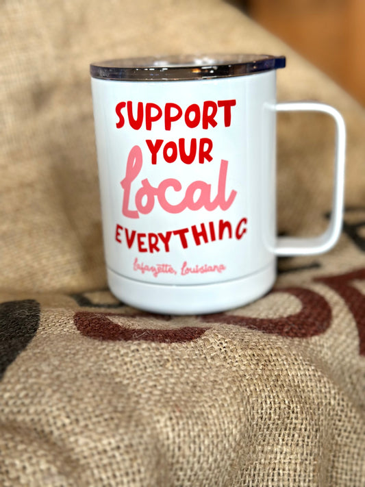 White mug with red and pink text on a textured surface