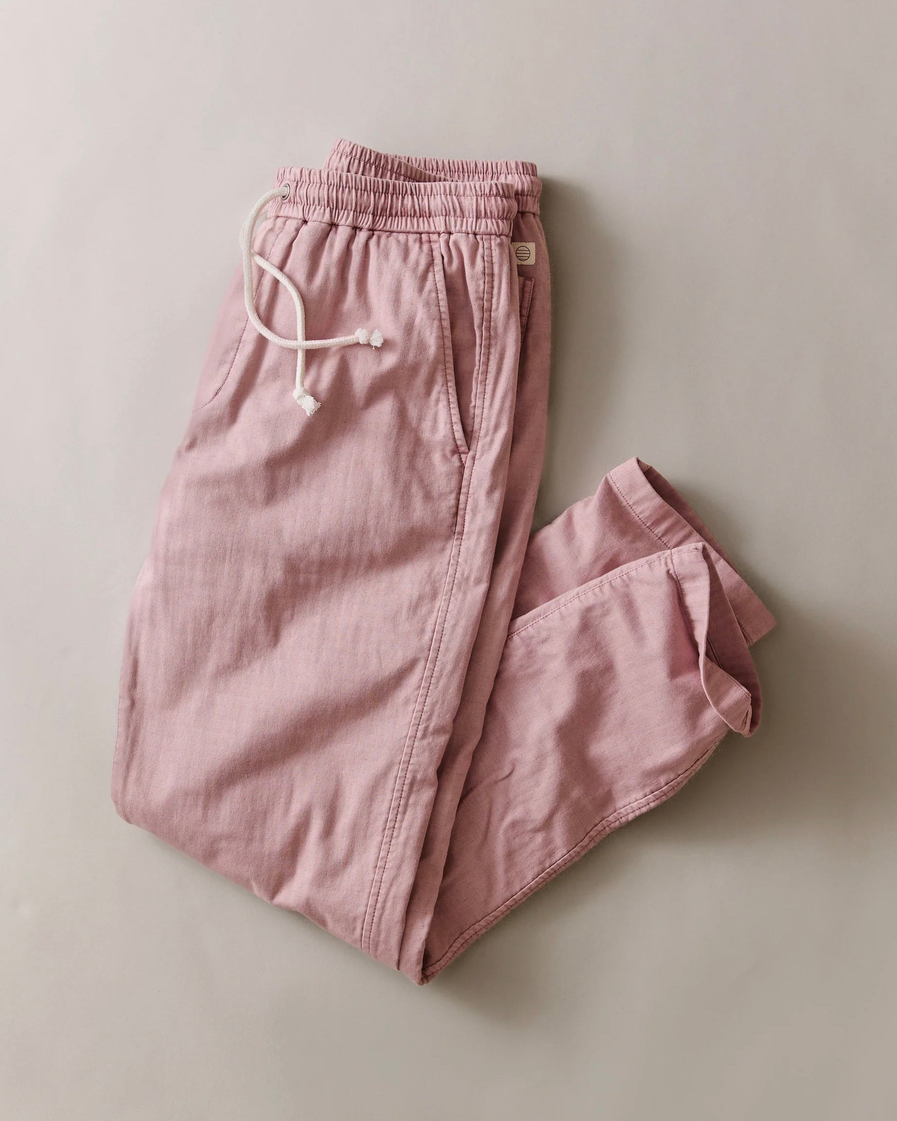 Pink pants with a drawstring on a light gray background