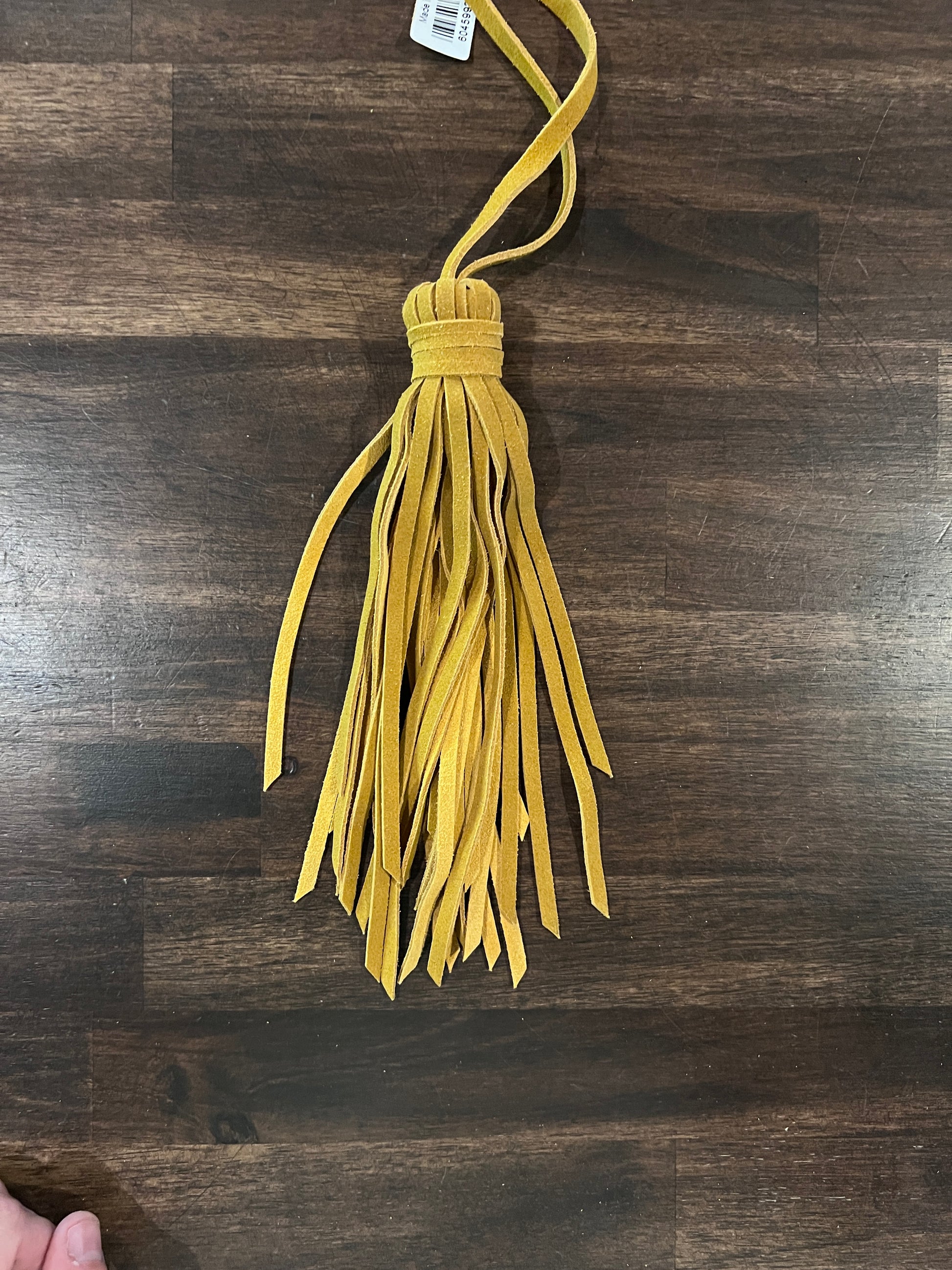 Yellow tassel on a wooden surface