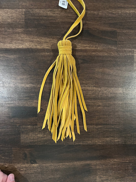 Yellow tassel on a wooden surface