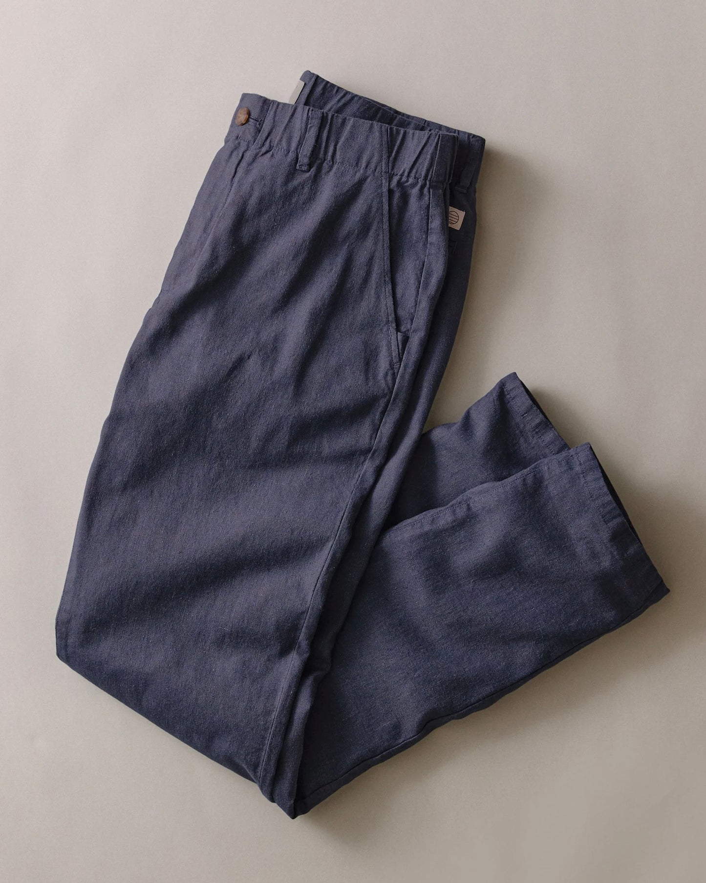 Pair of dark blue pants on a light beige background