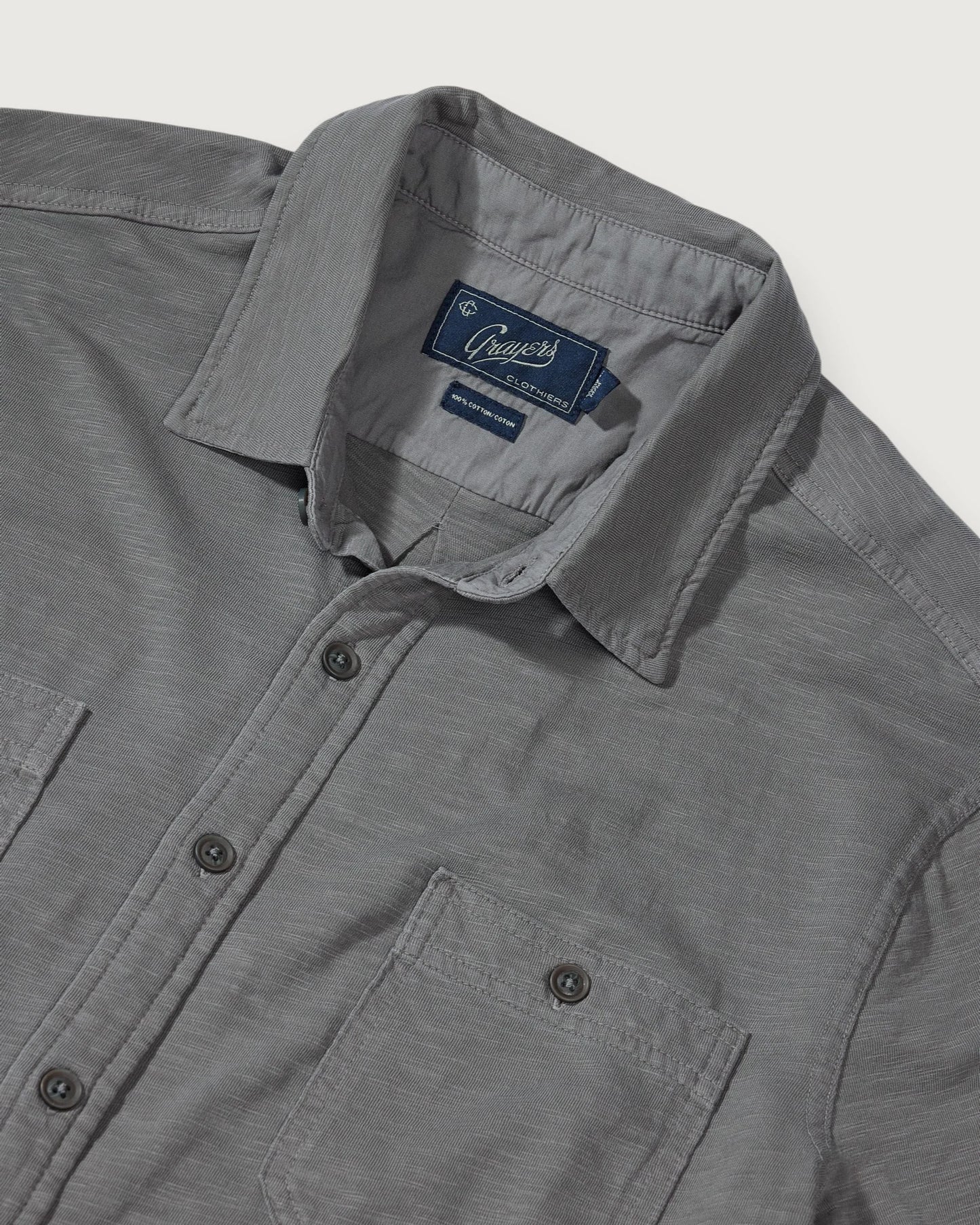 Gray button down shirt against white background