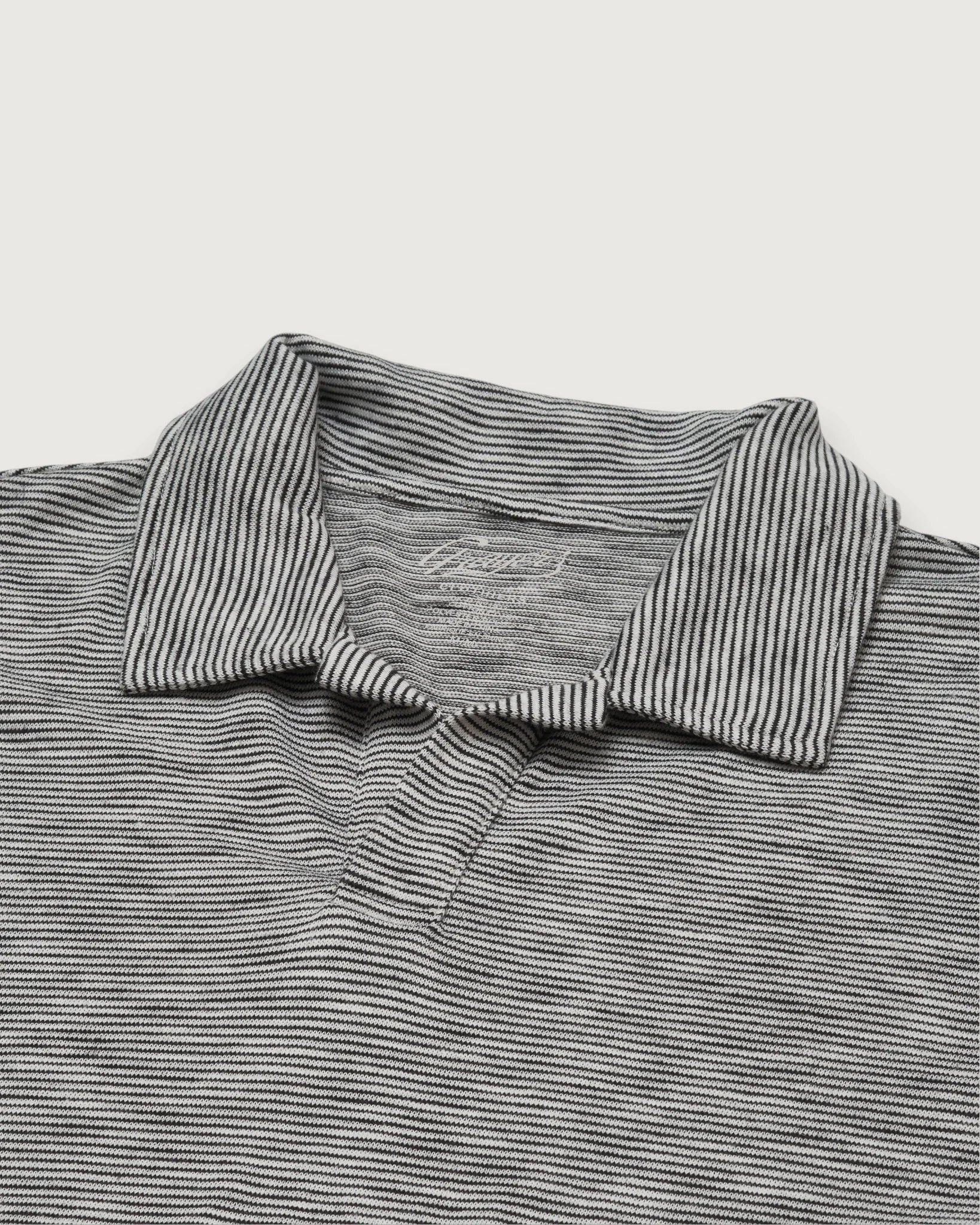 Close-up of a gray and white striped polo shirt on a light gray background