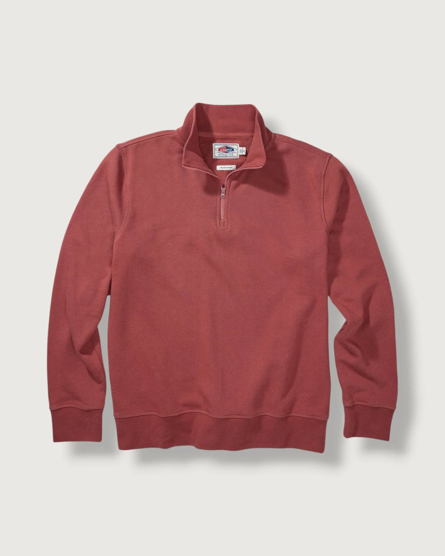 Red pullover with a brand logo on a light gray background