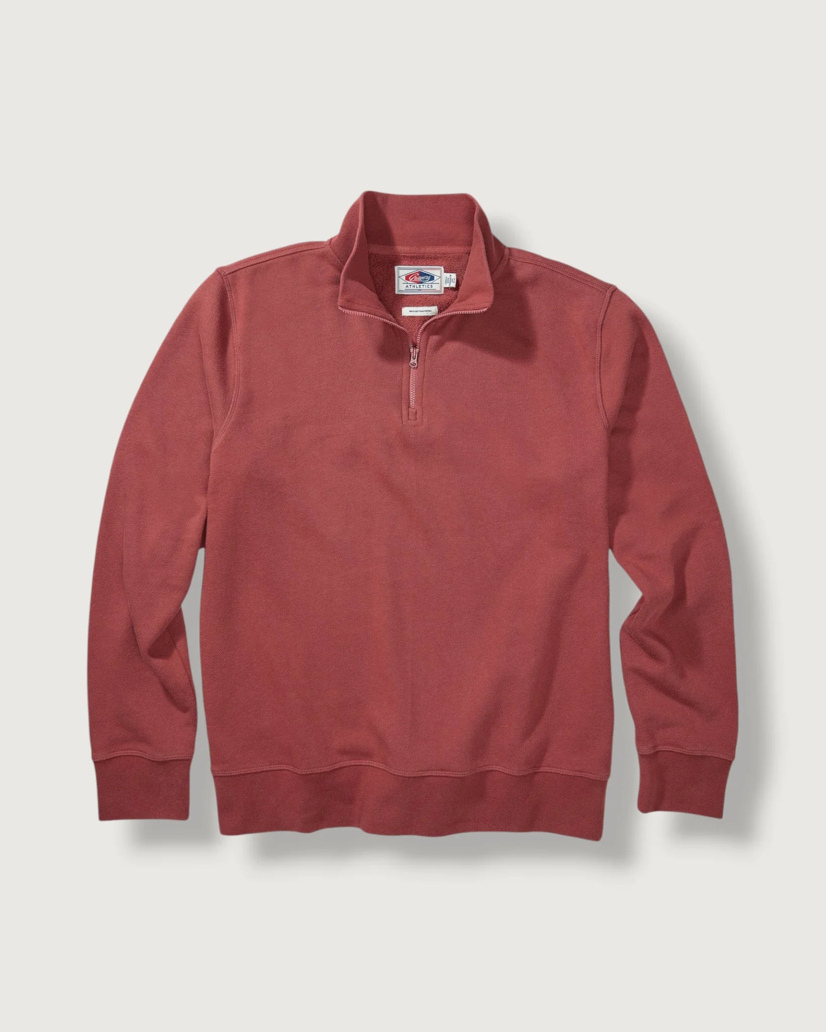 Red pullover with a brand logo on a light gray background