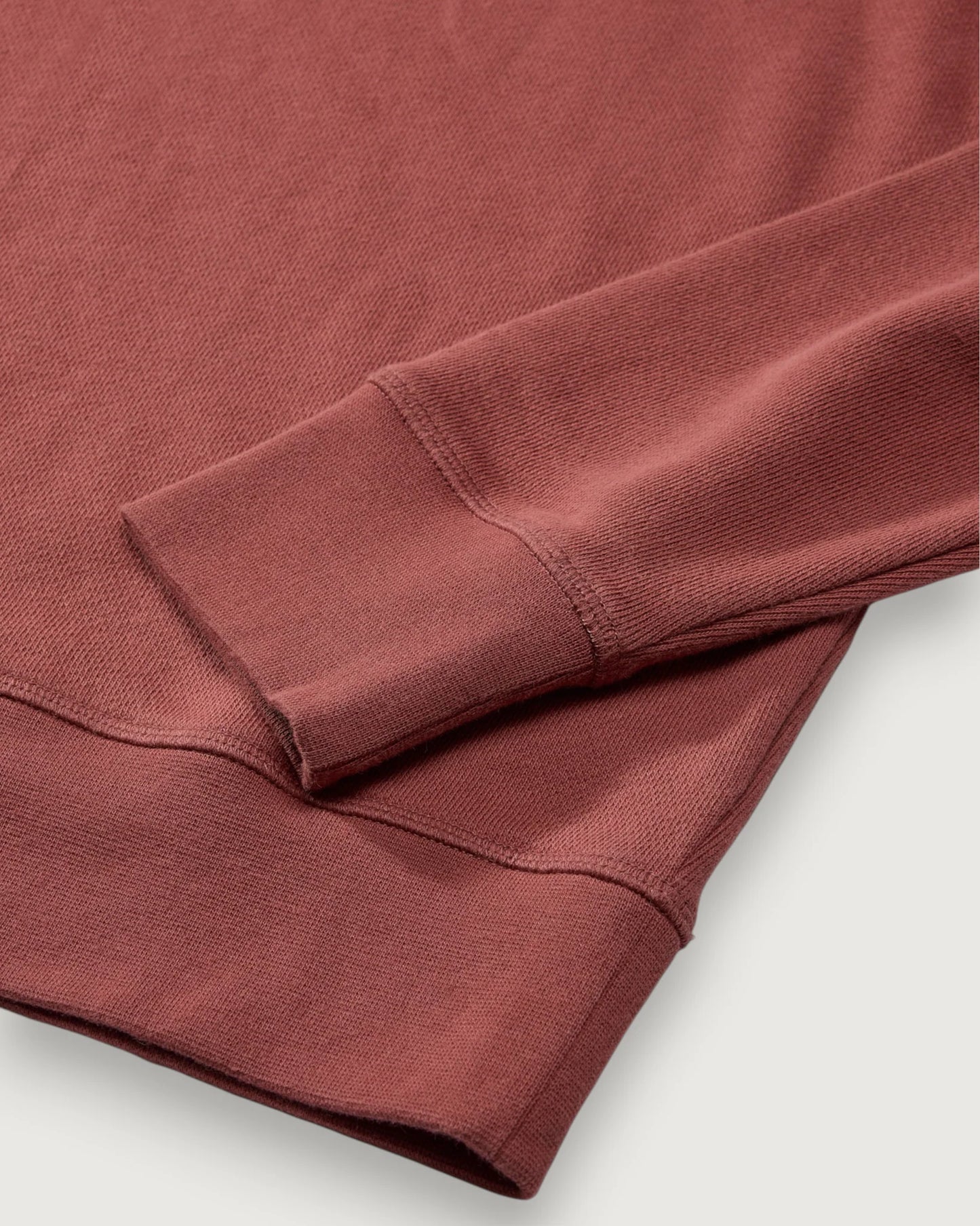 Close-up of a folded red-brown fabric on a light gray background