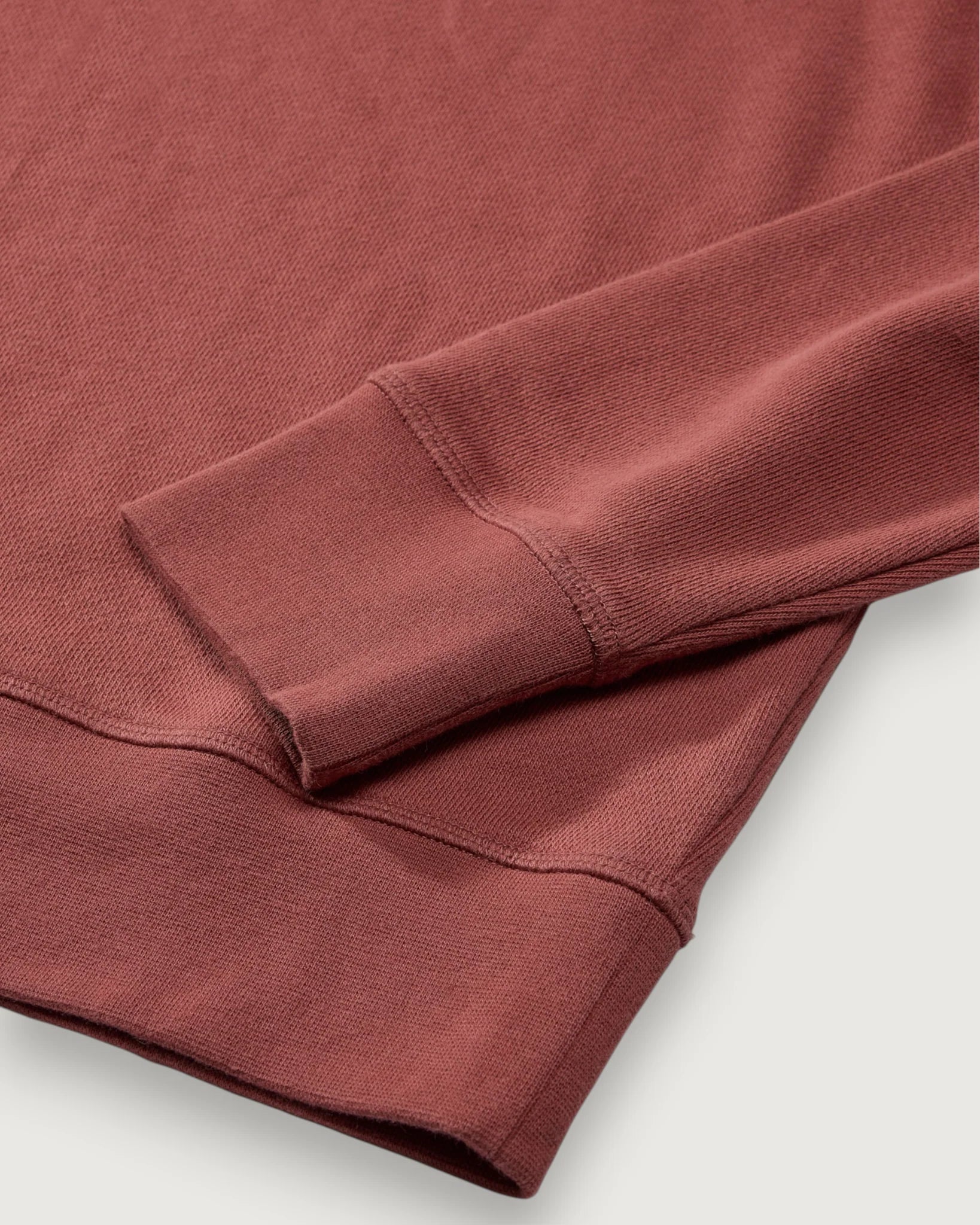 Close-up of a folded red-brown fabric on a light gray background