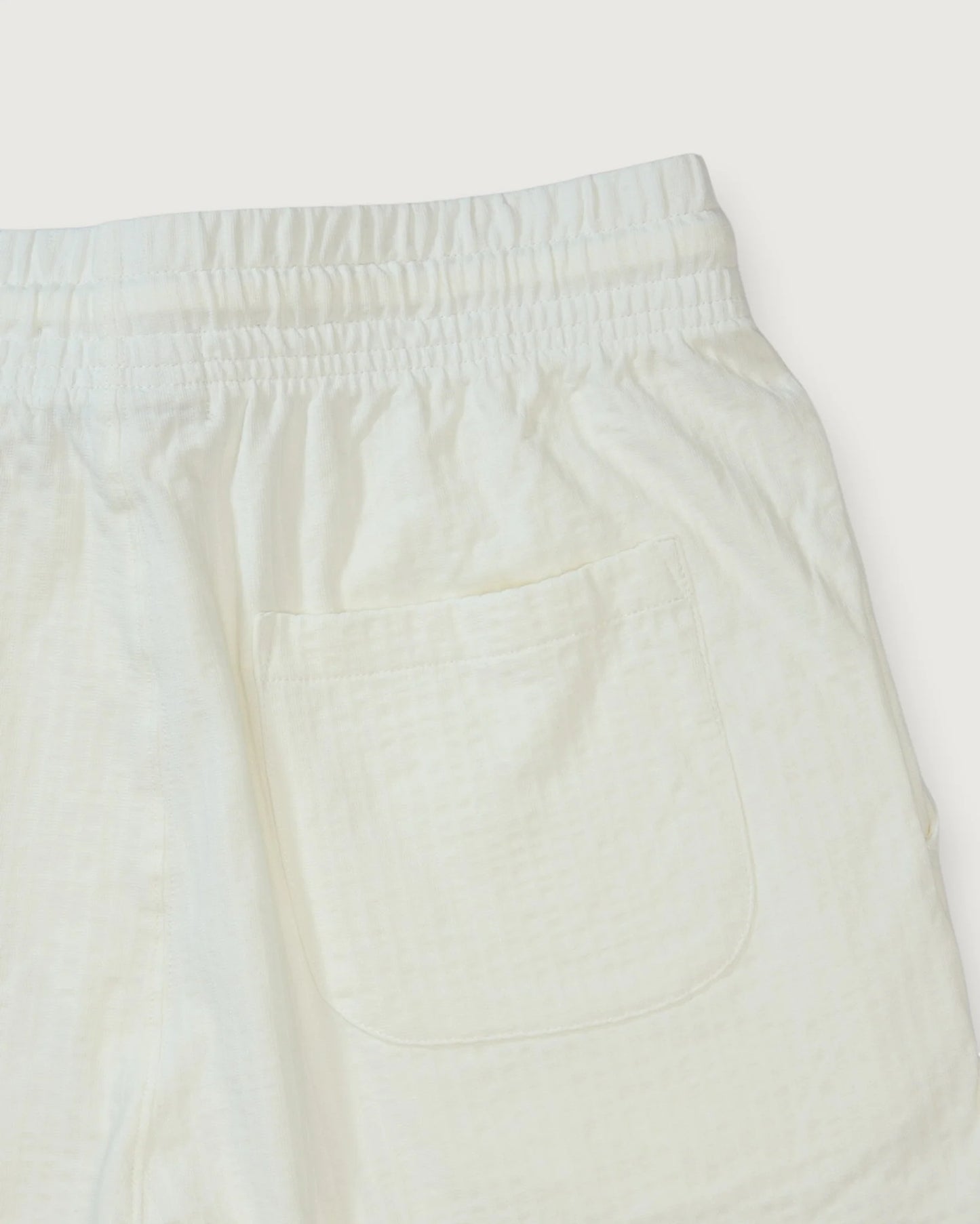 Close-up of cream-colored pants on a white background