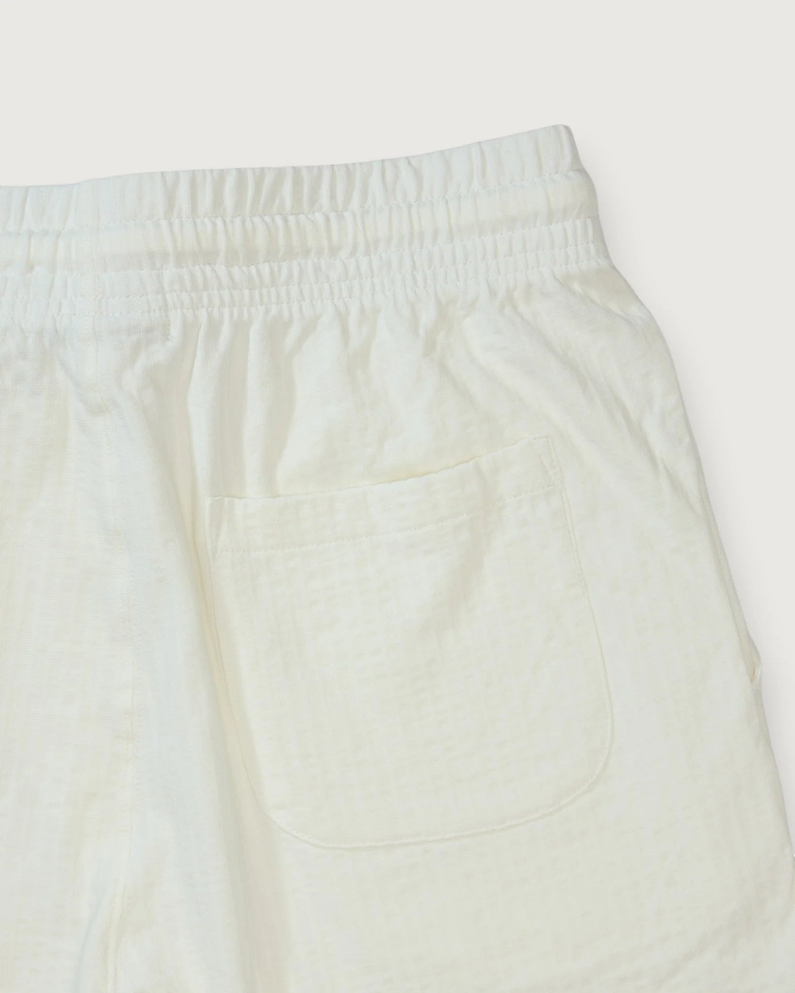 Close-up of cream-colored pants on a white background