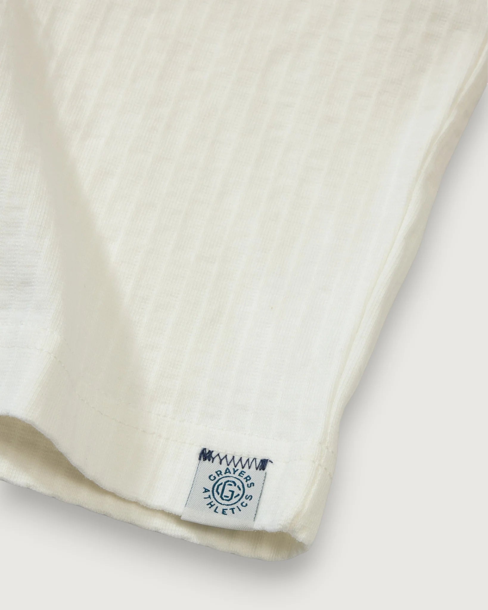 Close-up of a beige fabric with a brand label on a white background