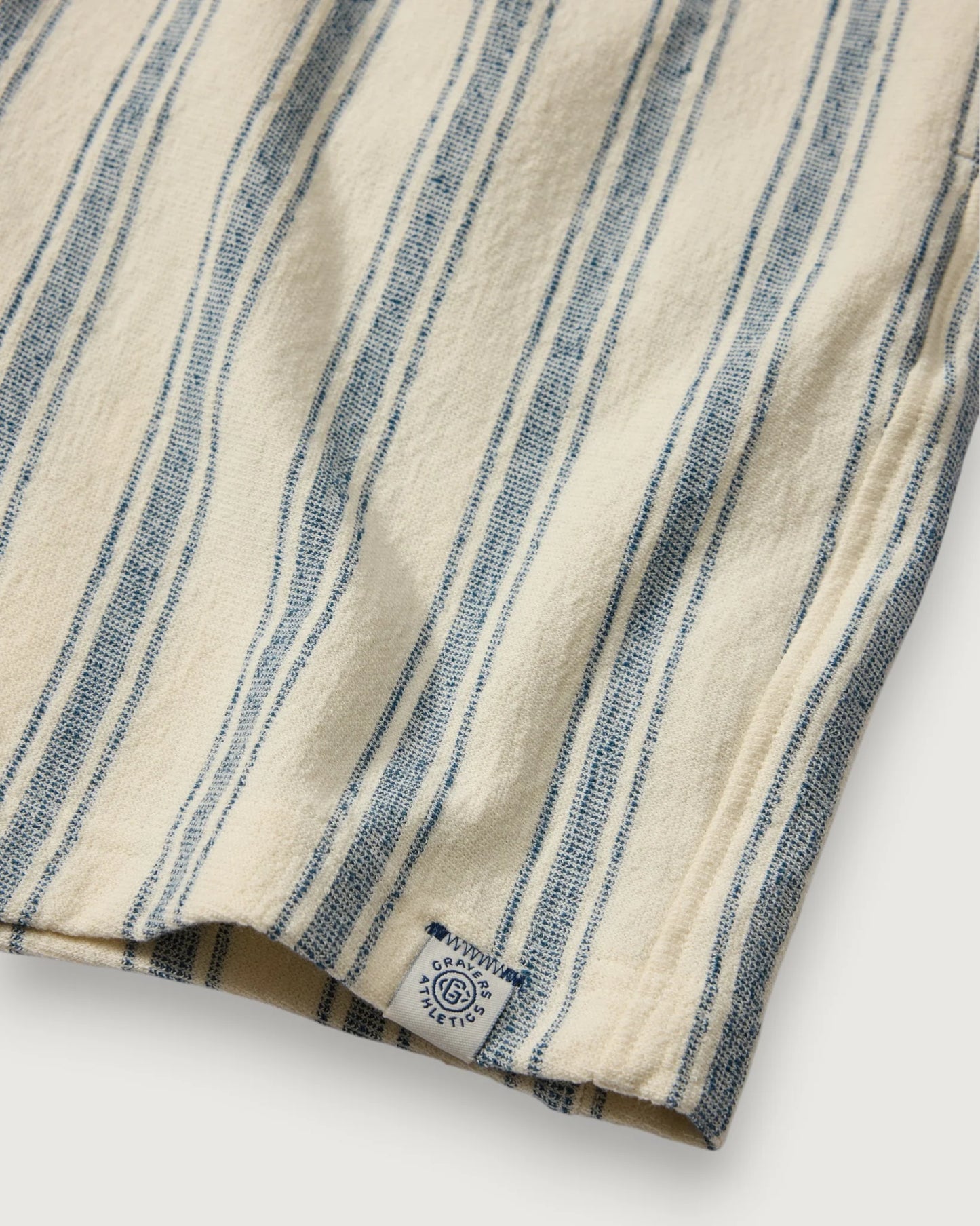 Close-up of a folded fabric with blue and beige stripes on a white background