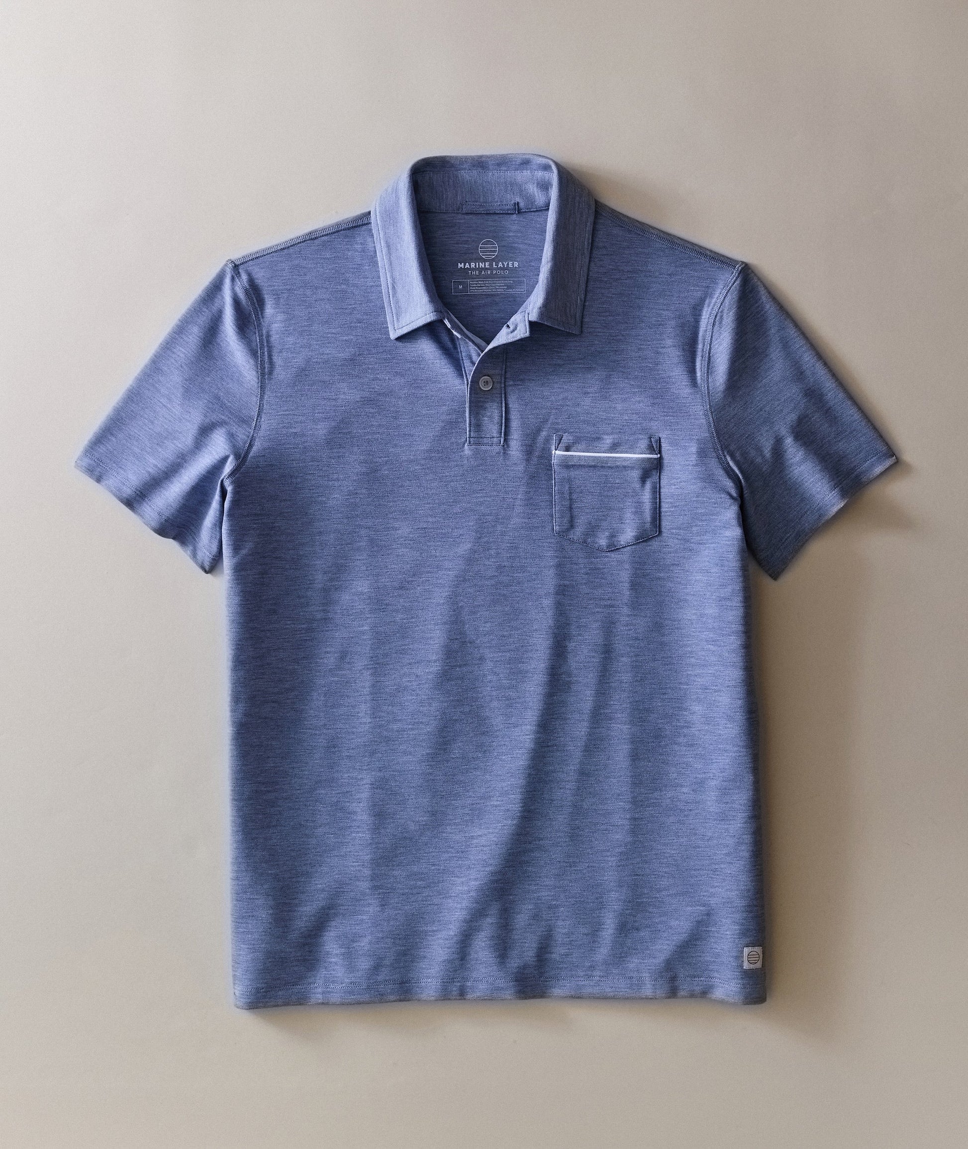 Blue polo shirt with a pocket on a beige background