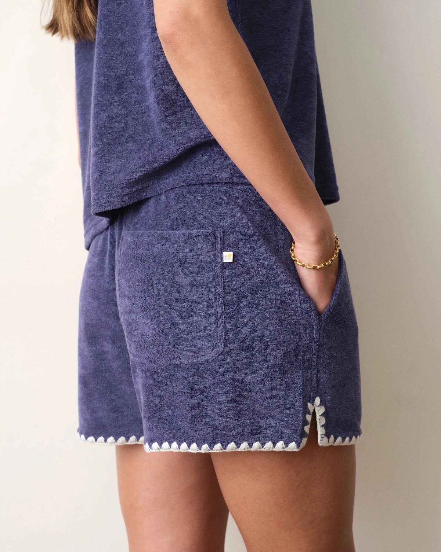 Navy blue shorts with white trim on a neutral background