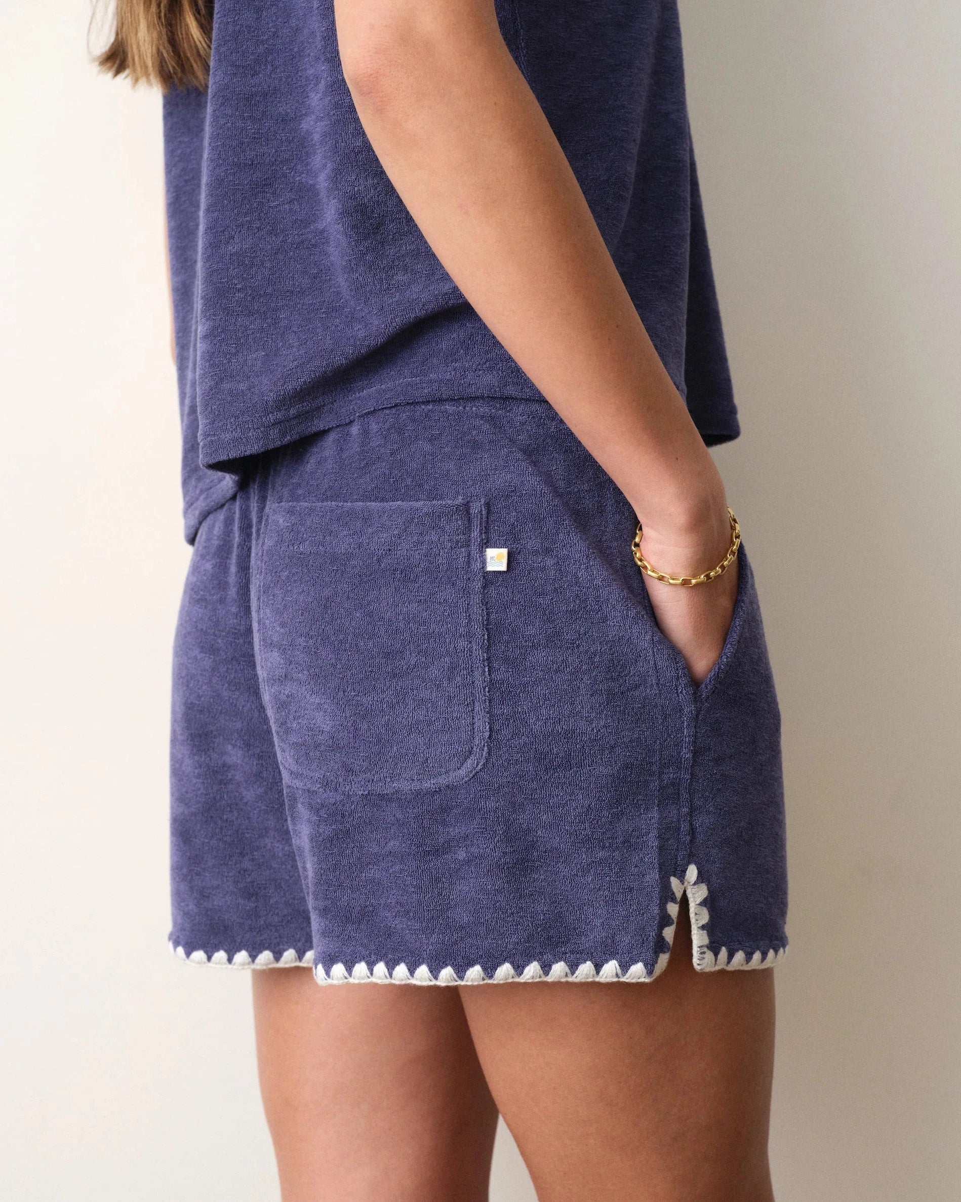 Navy blue shorts with white trim on a neutral background