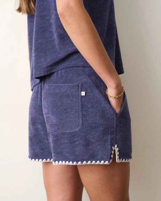 Navy blue shorts with white trim on a neutral background