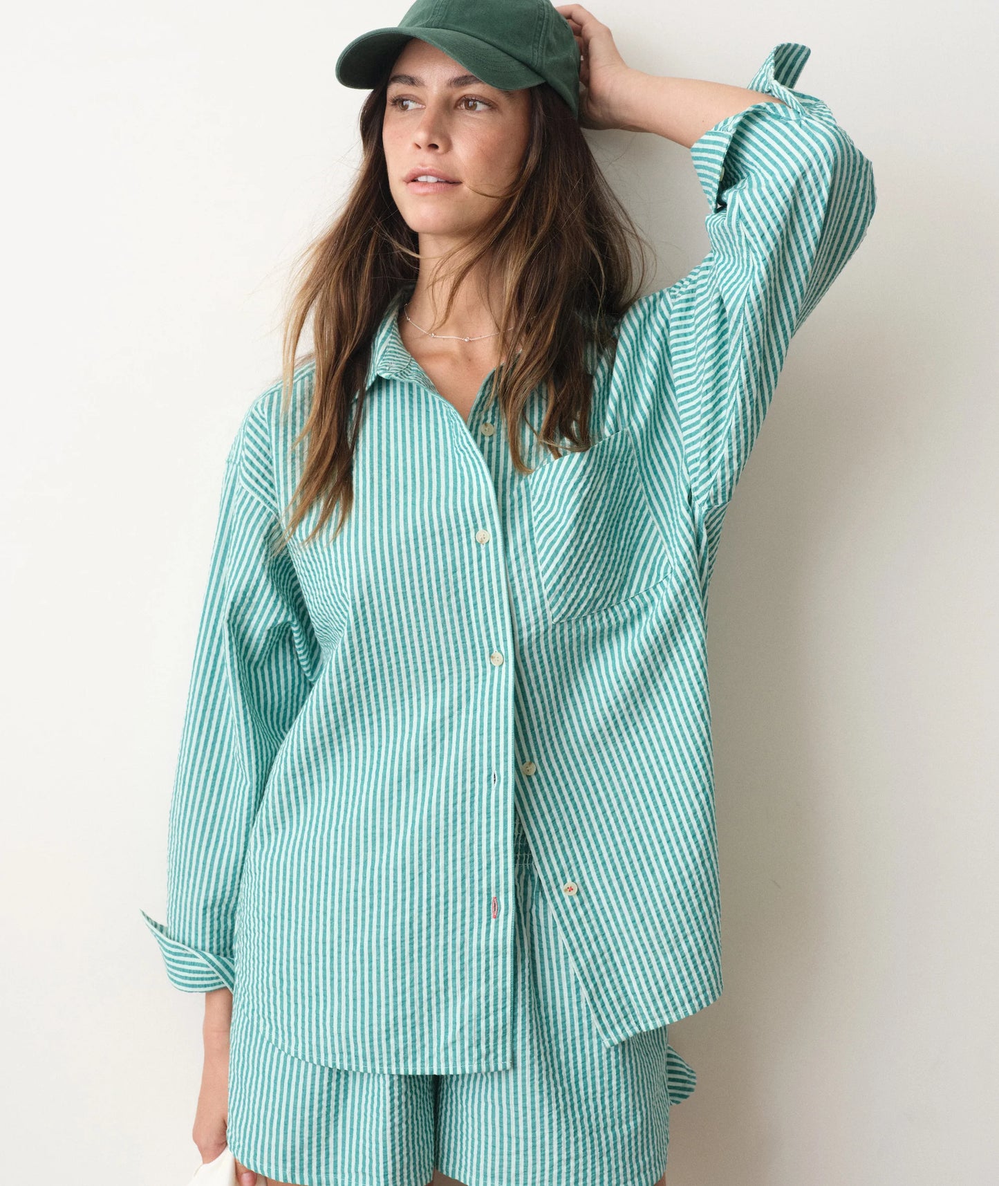 green seersucker striped shirt on a person in front of a white background