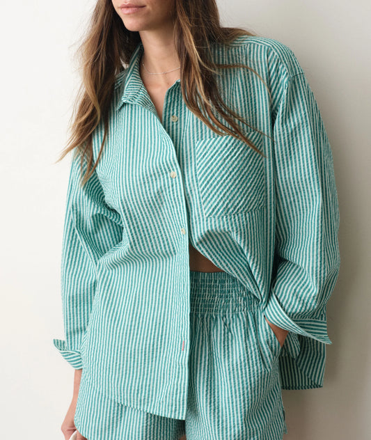 Green striped seersucker shirt on a person in front of a white background