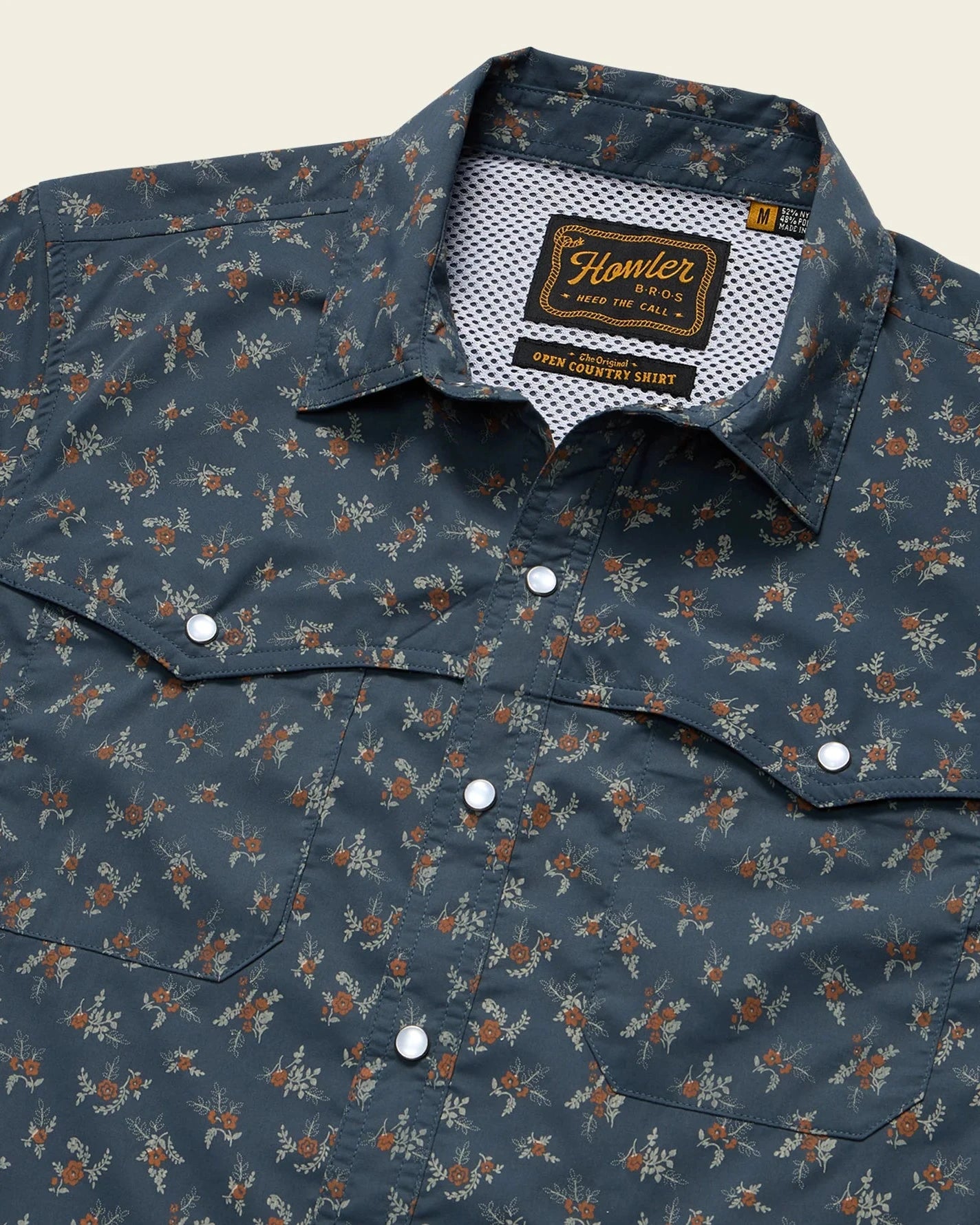 Floral patterned shirt with a brand label on a beige background