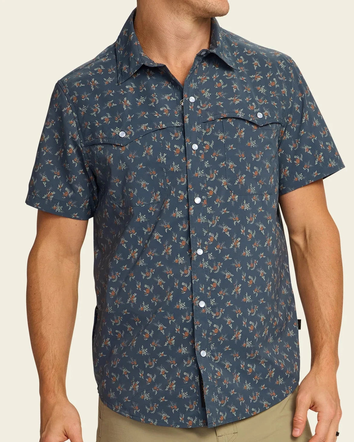 Man wearing a patterned short-sleeve shirt on a beige background