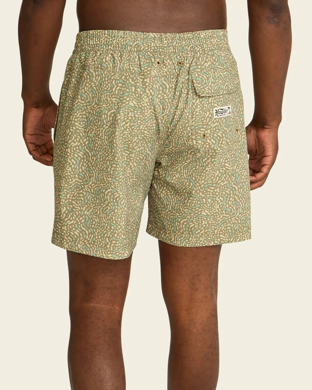 Person wearing patterned shorts on a beige background
