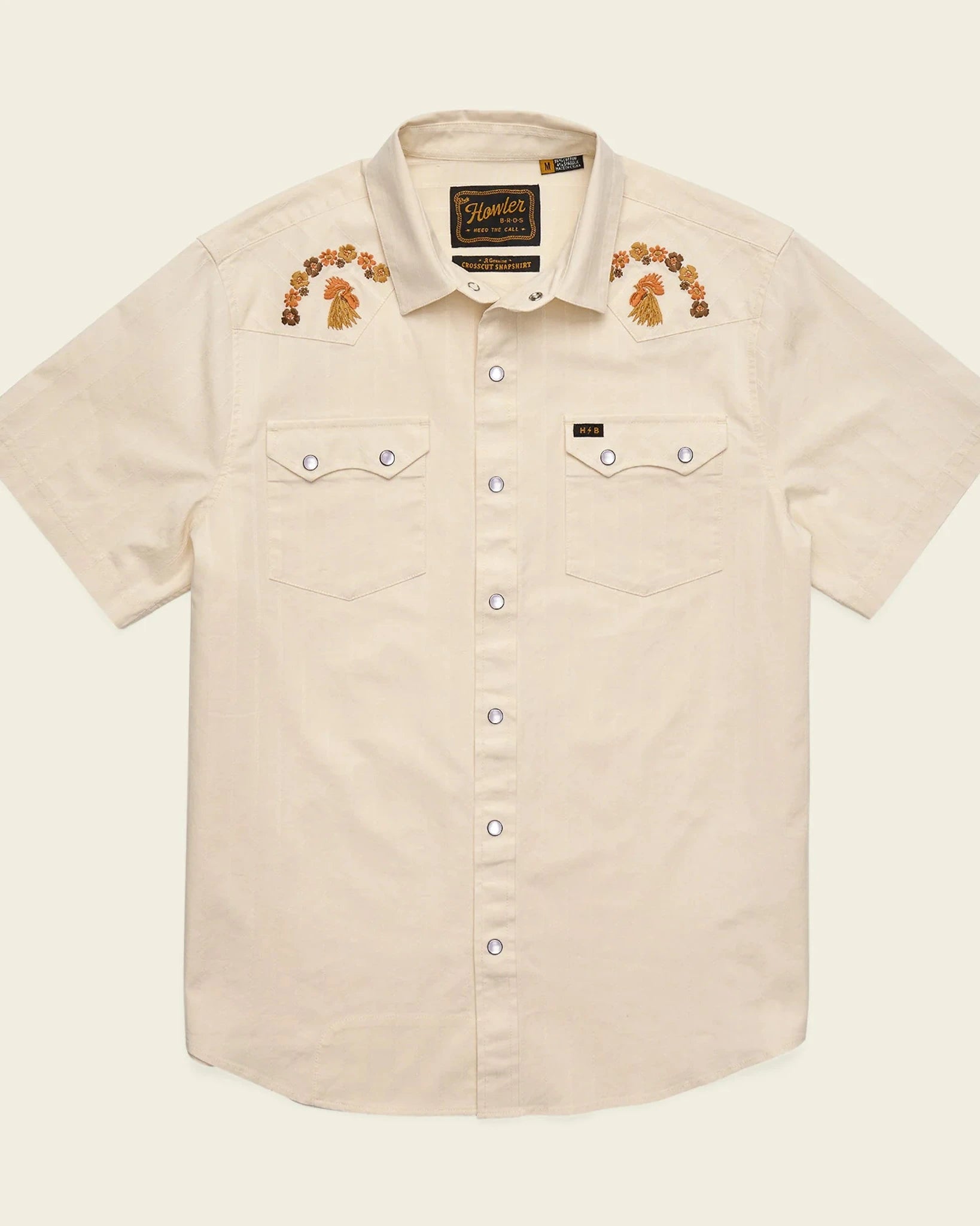 Beige short-sleeve shirt with embroidered designs on a beige background