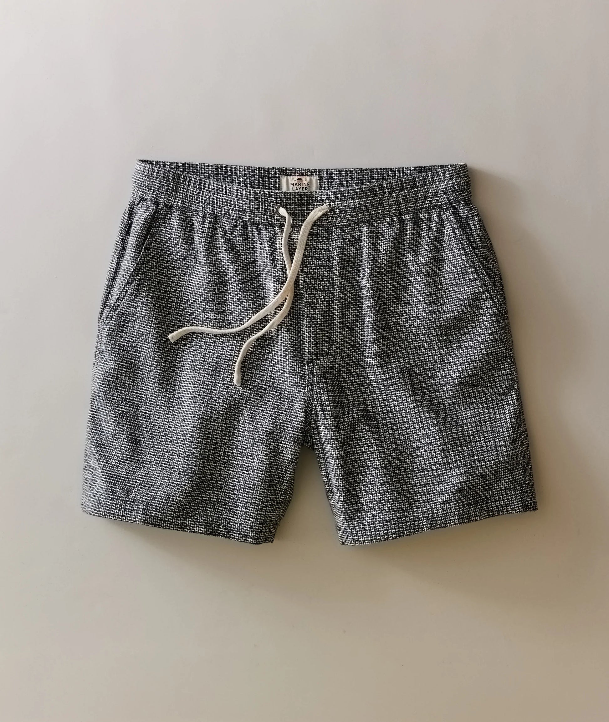 Gray shorts with a white drawstring on a beige background