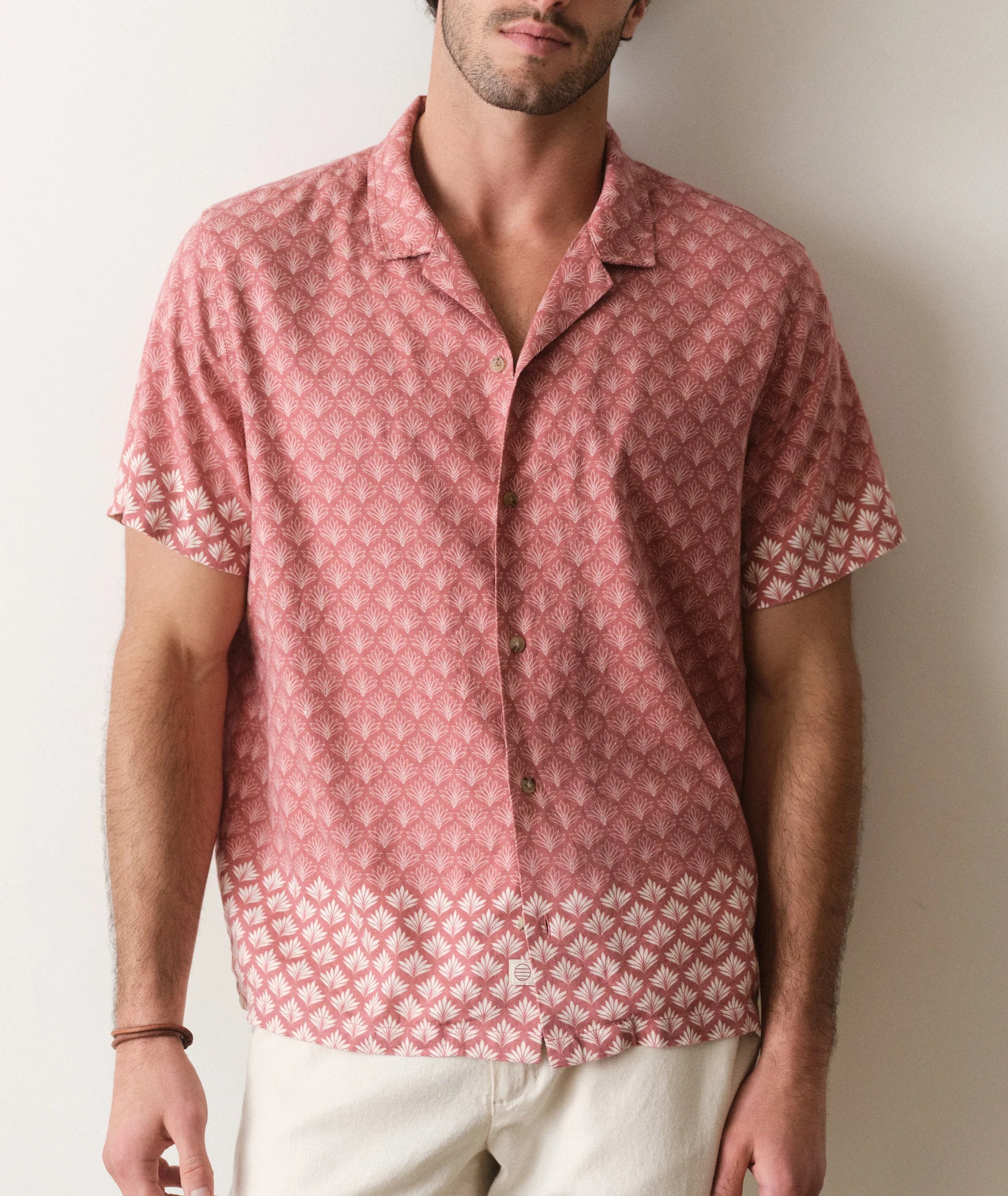 Man wearing a red patterned shirt against a plain background