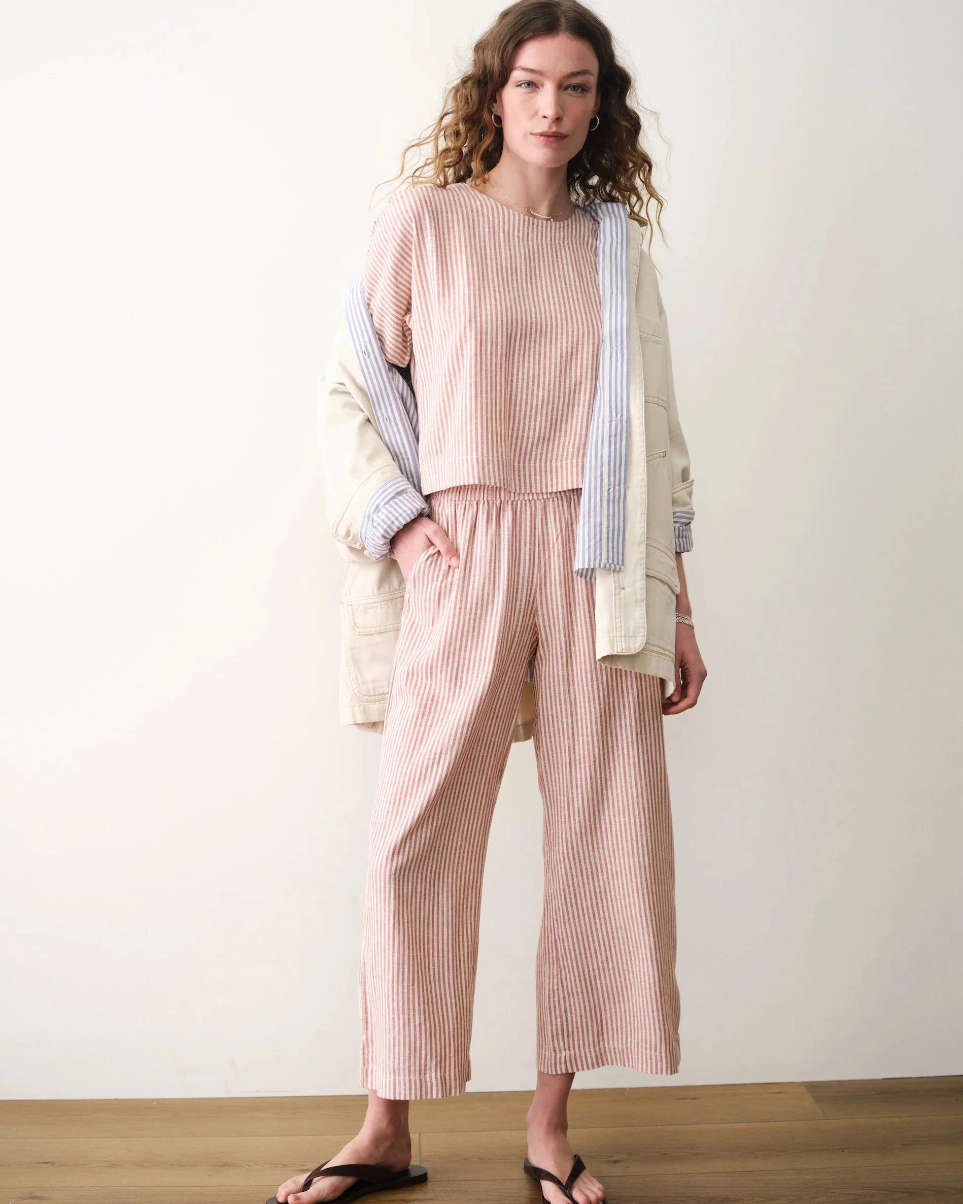 Woman wearing a pink striped outfit with a white background