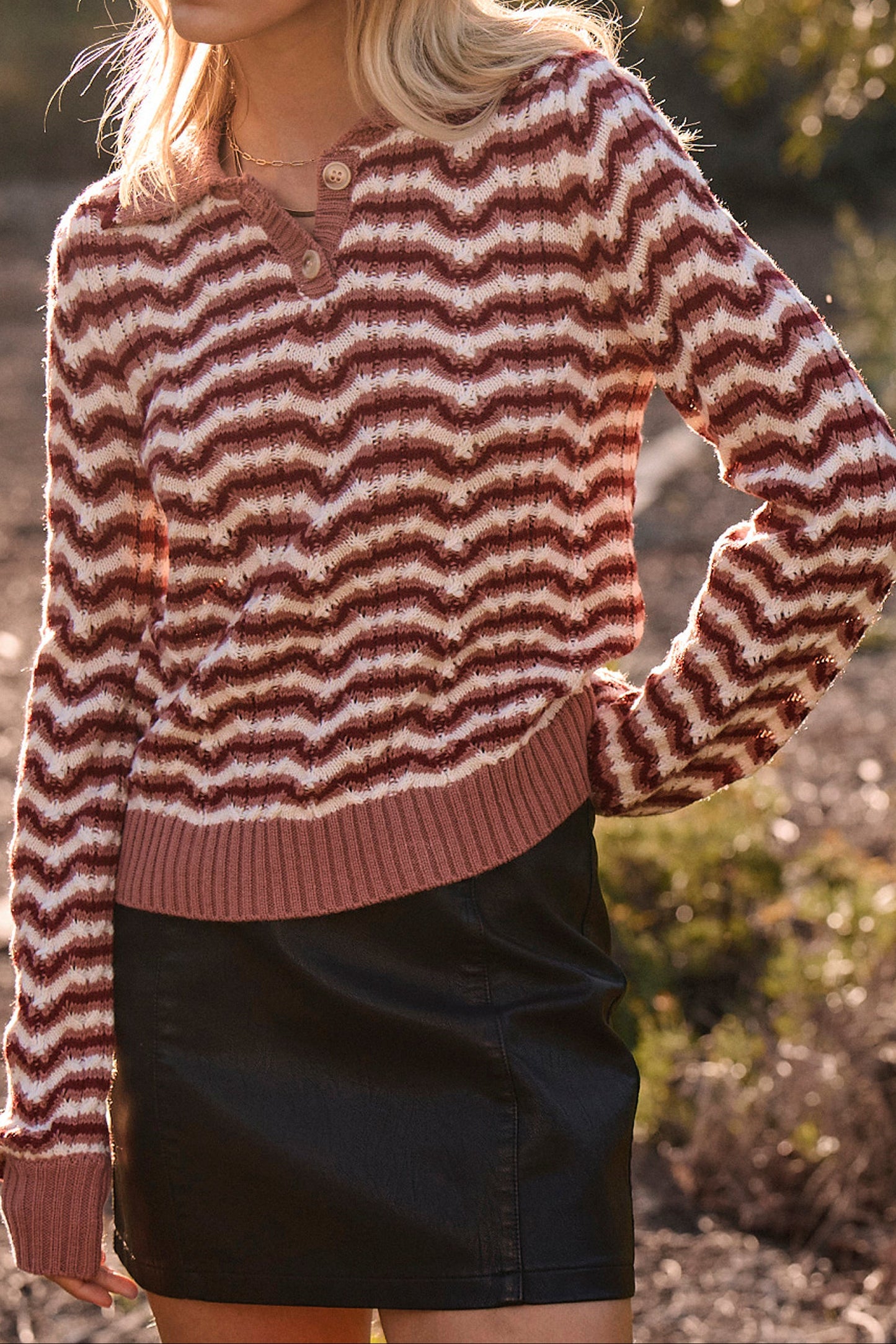 Woman wearing a striped sweater and black skirt outdoors