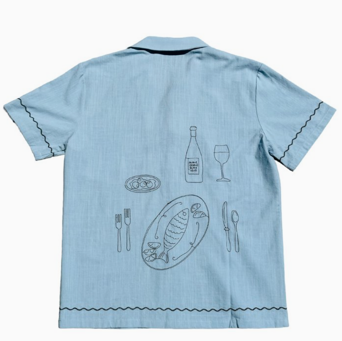 Back of a light blue woven shirt with an embroidered dinner scene 