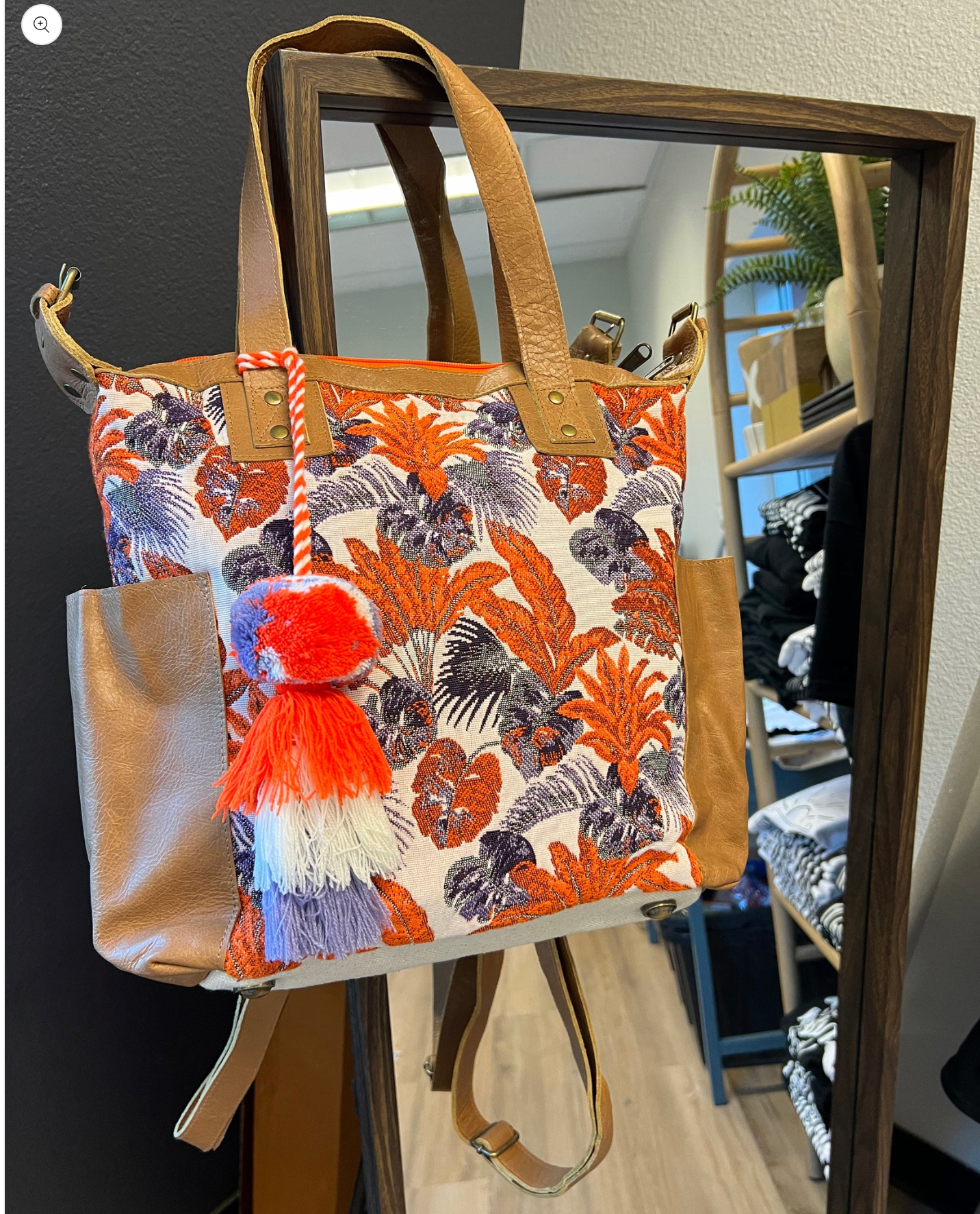 A floral tote hangs from a mirror