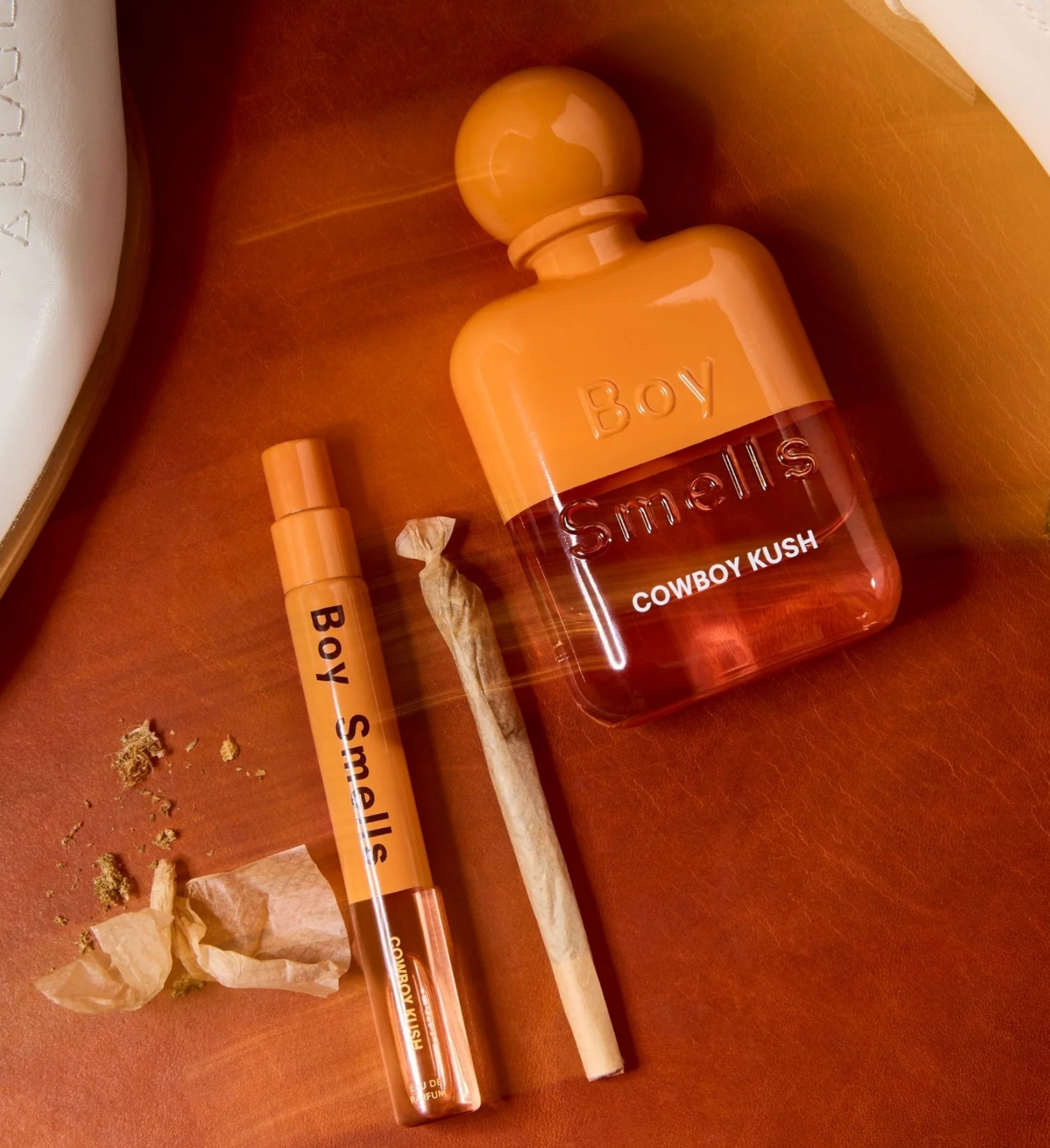 Boy Smells Cowboy Kush perfume bottle and packaging on a brown surface