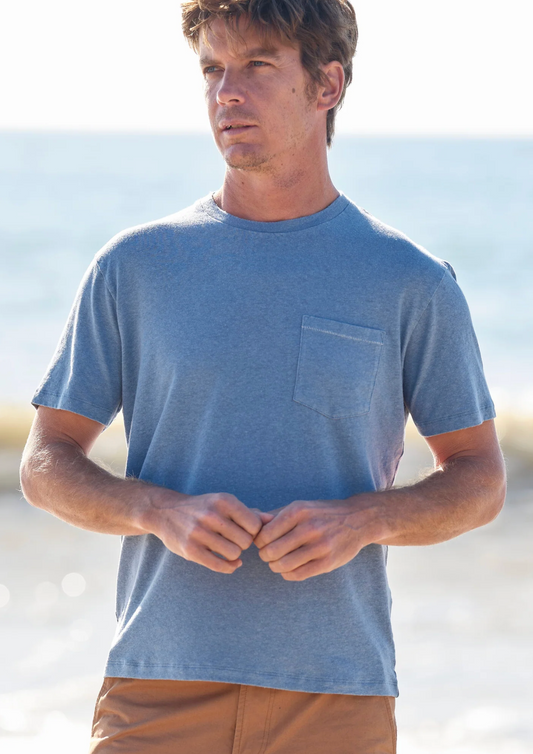 Man wearing a blue t-shirt with a pocket on a beach