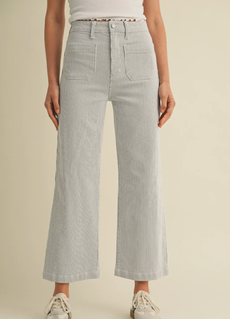Person wearing light gray checkered pants on a beige background