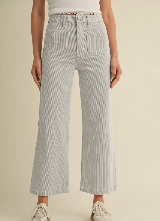 Person wearing light gray checkered pants on a beige background