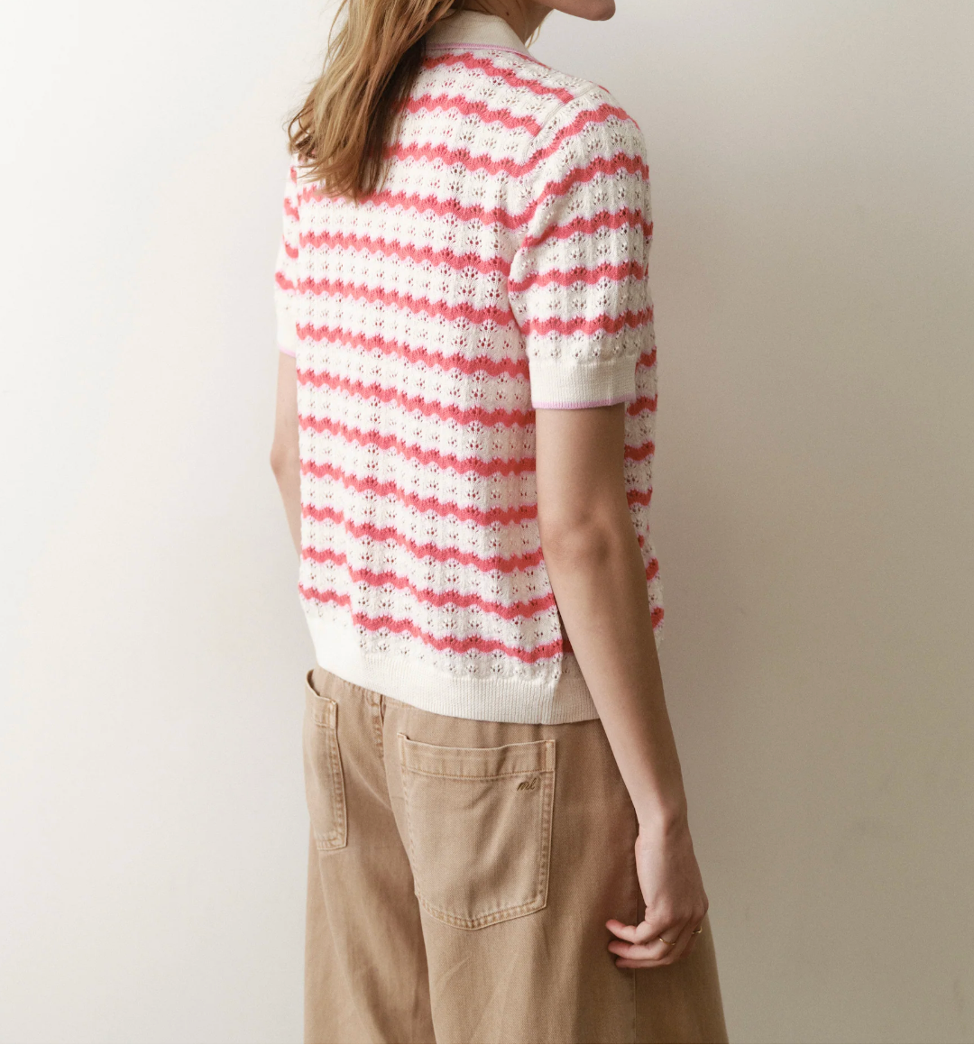Person wearing a red and white striped shirt against a plain background