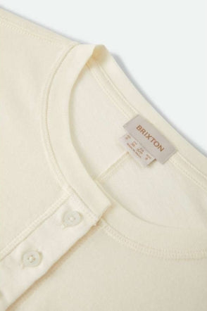 Close-up of a beige shirt with a Brixton label on a white background
