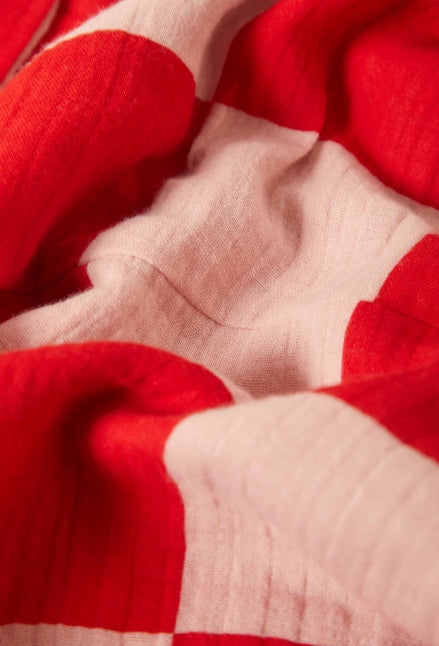 Close-up of red and beige fabric with a visible seam