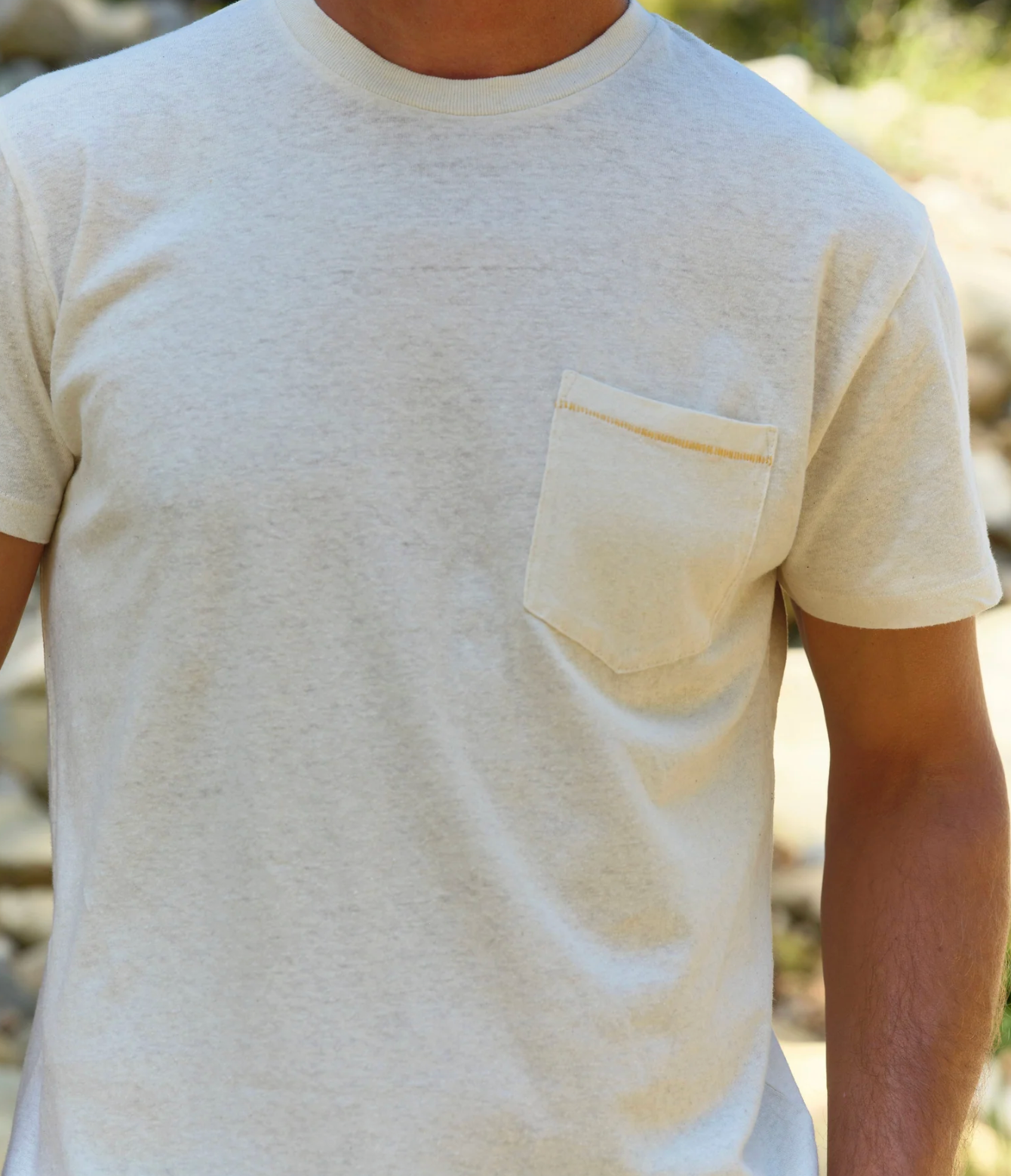 Beige t-shirt with a pocket worn by a person outdoors