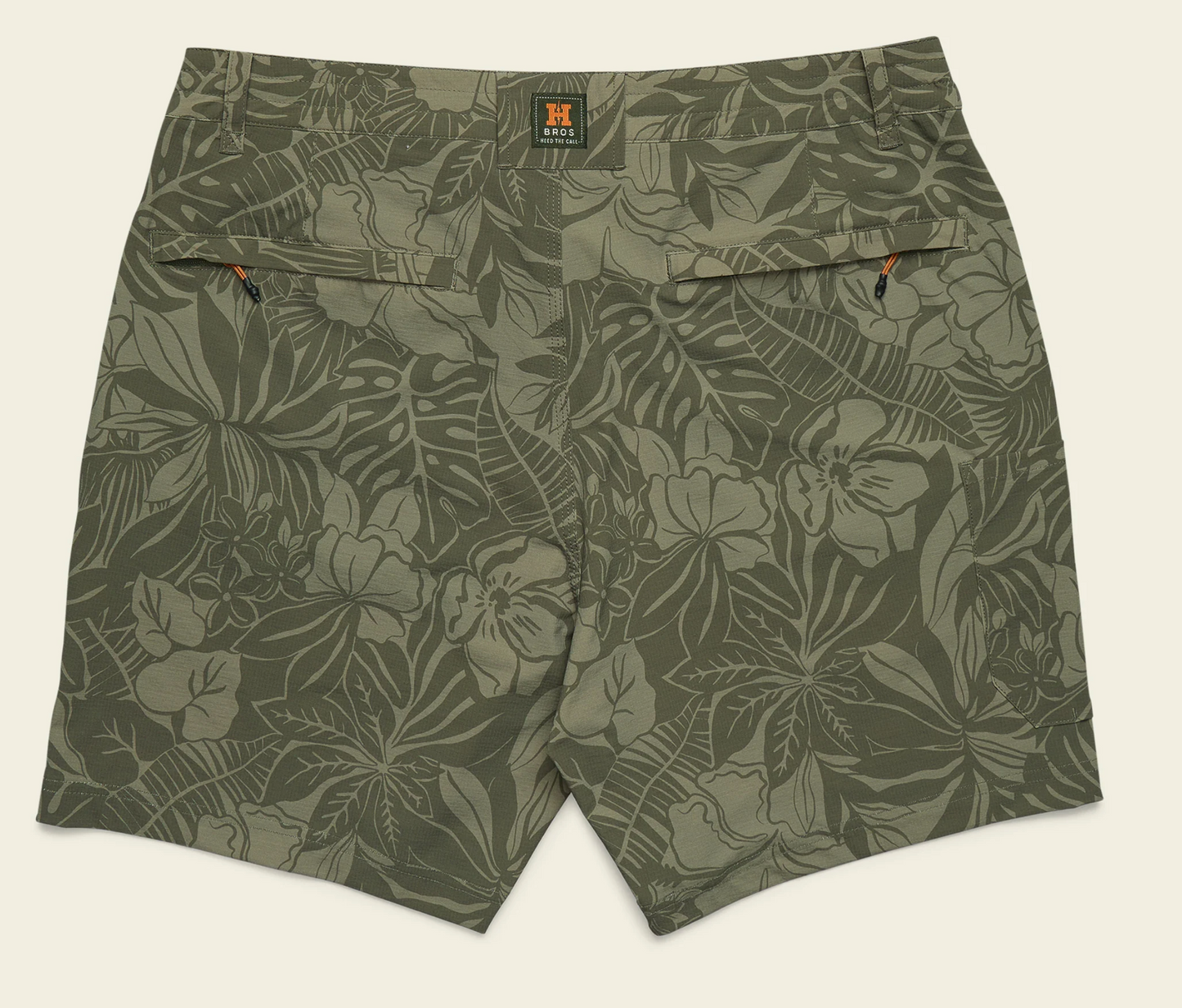 Green floral-patterned shorts on a beige background