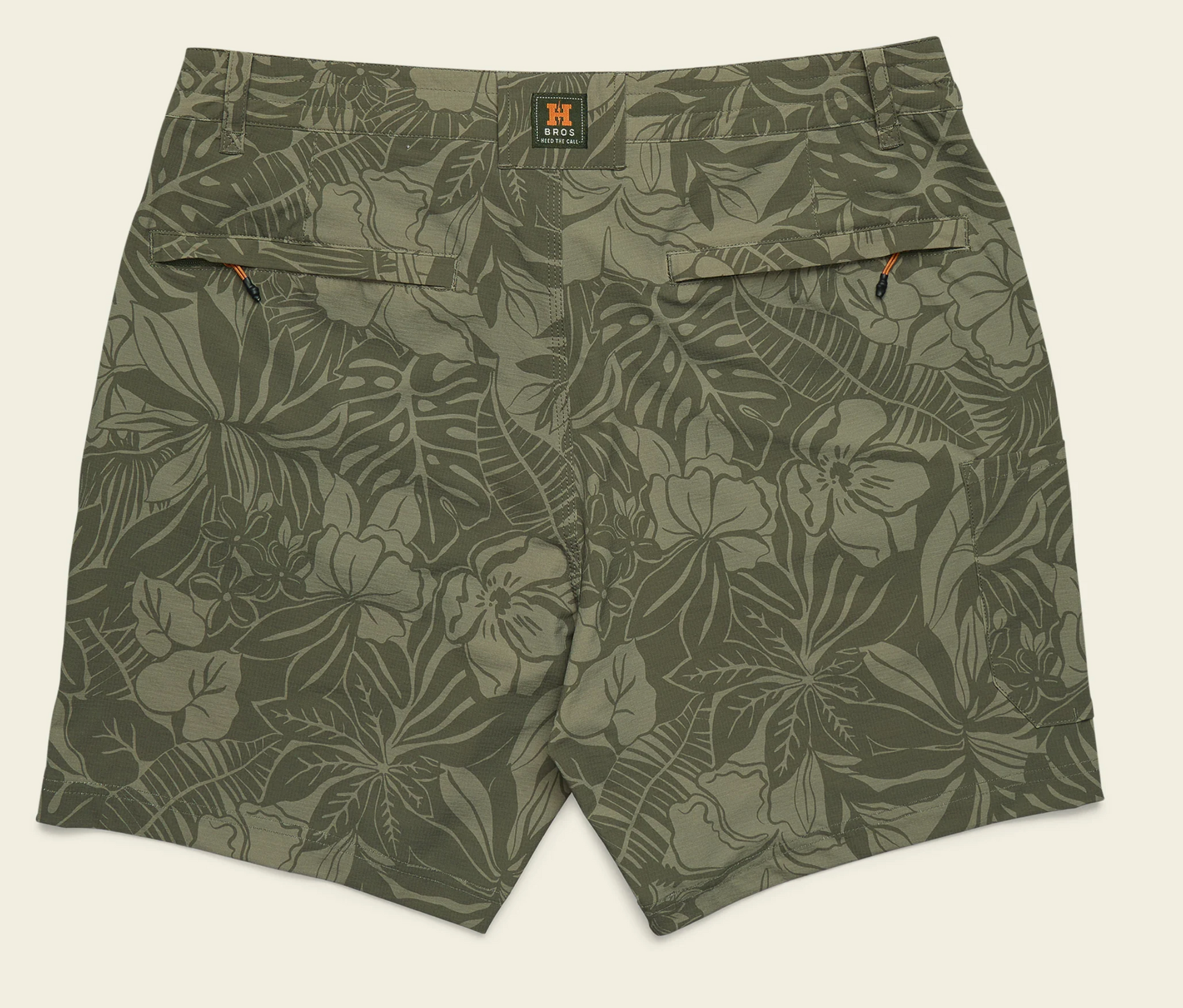 Green floral-patterned shorts on a beige background