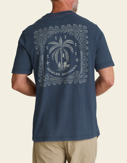 Man wearing a navy blue t-shirt with a palm tree design and 'Howler Brothers' branding on the back.