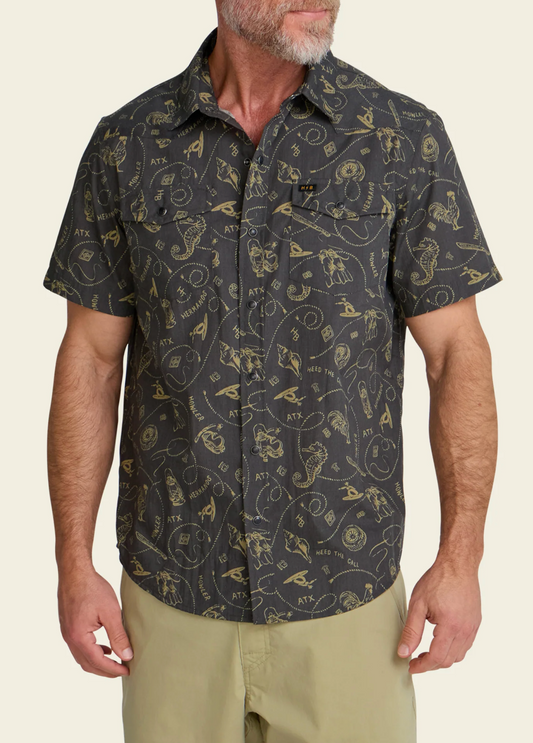 Man wearing a patterned short-sleeve shirt on a beige background