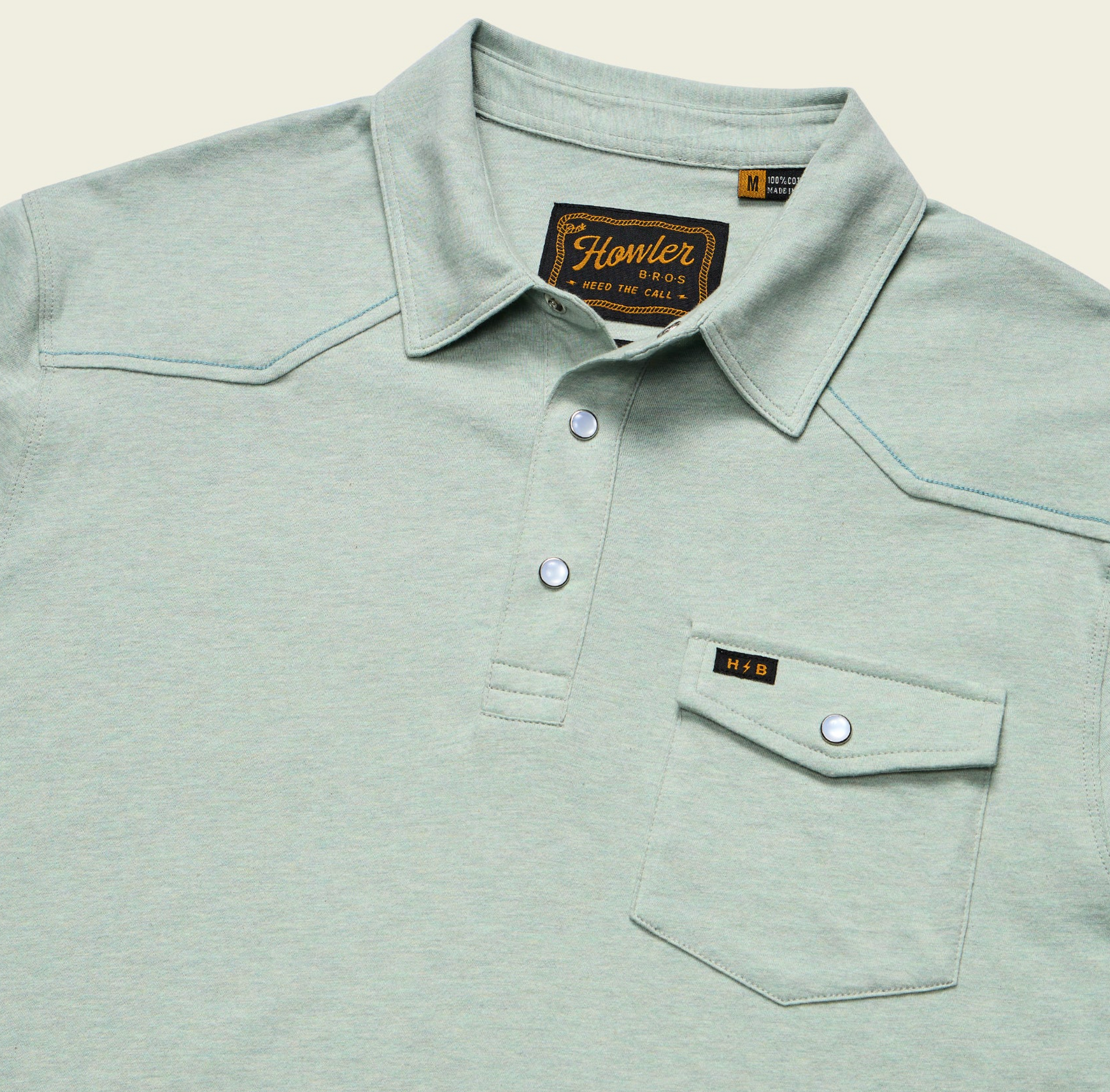 Light green polo shirt with collar and pocket details on a beige background