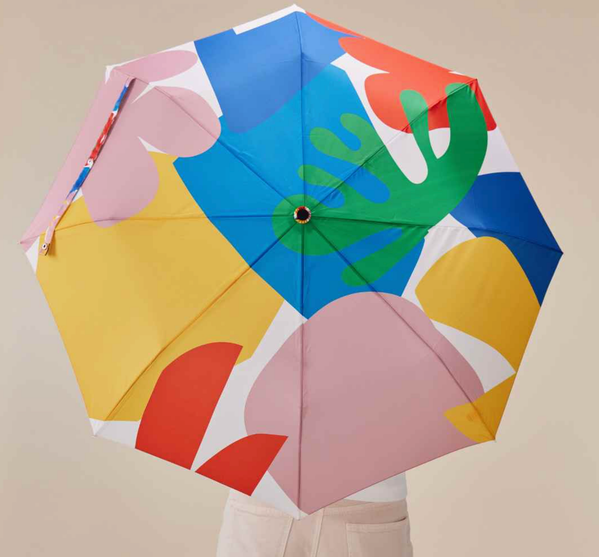 Colorful umbrella with abstract patterns on a beige background
