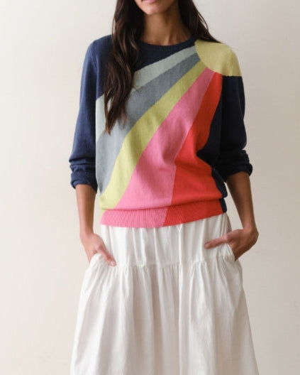 Woman wearing a colorful sweater with a neutral background