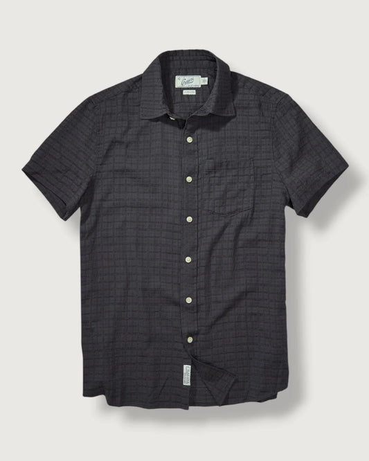 Black checkered short-sleeve shirt on a light gray background